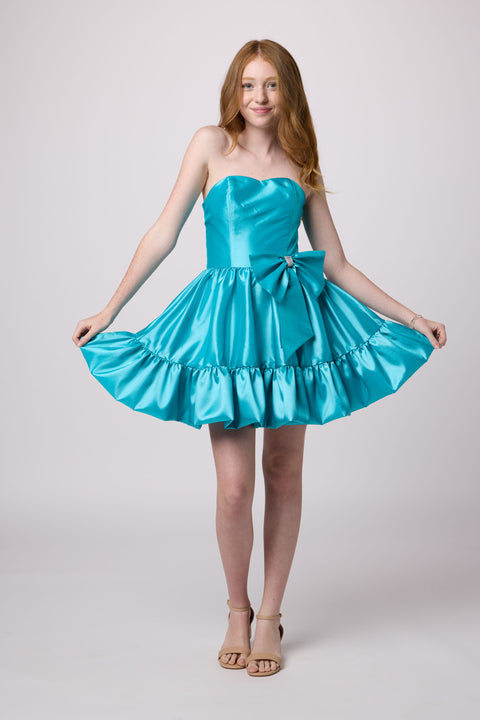 Red head in a turquoise bubble bow dress.
