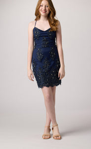Red head in a navy beaded dress with nude heel.