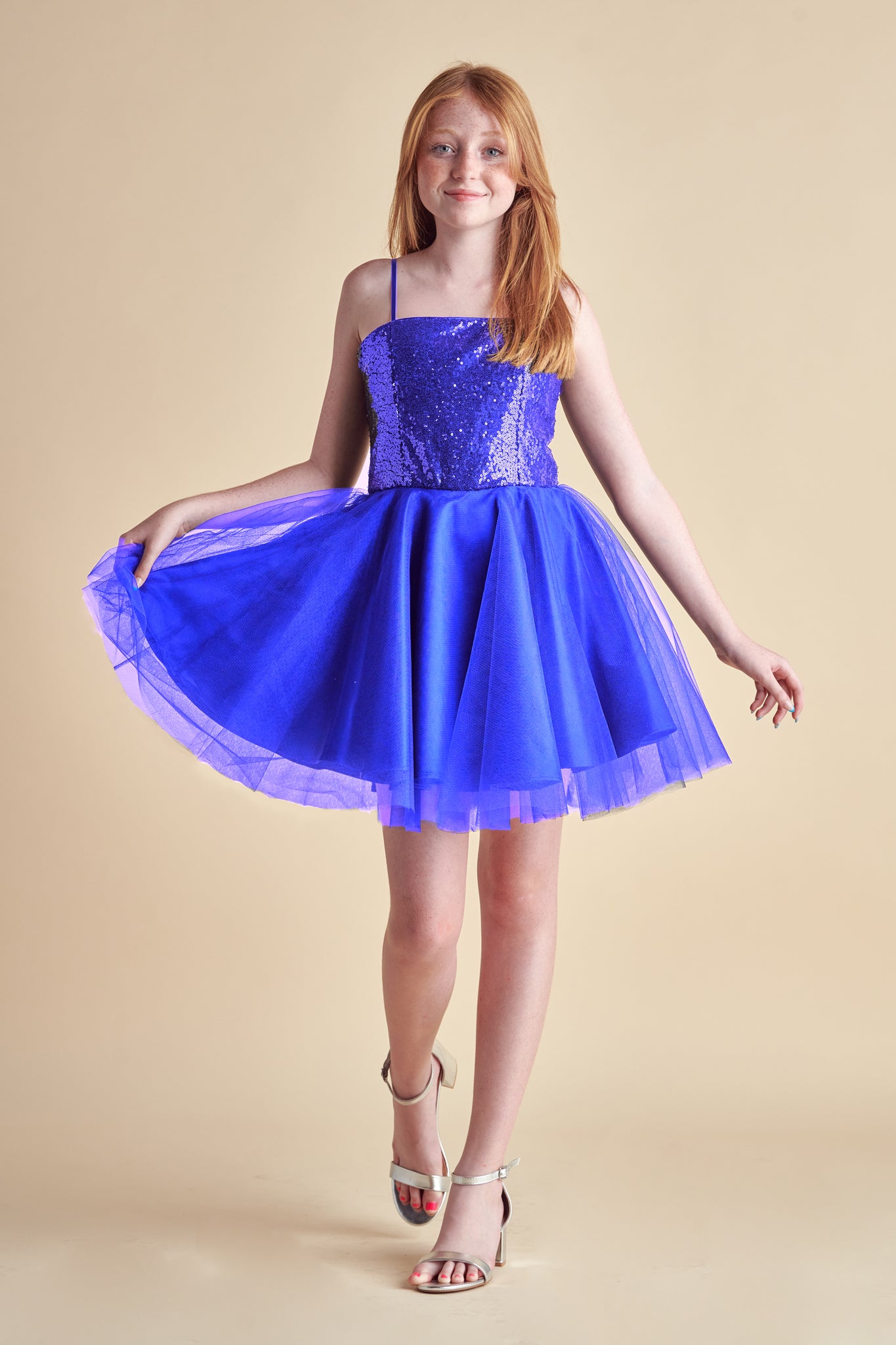 Red head wearing a cobalt blue sequin and satin dress.