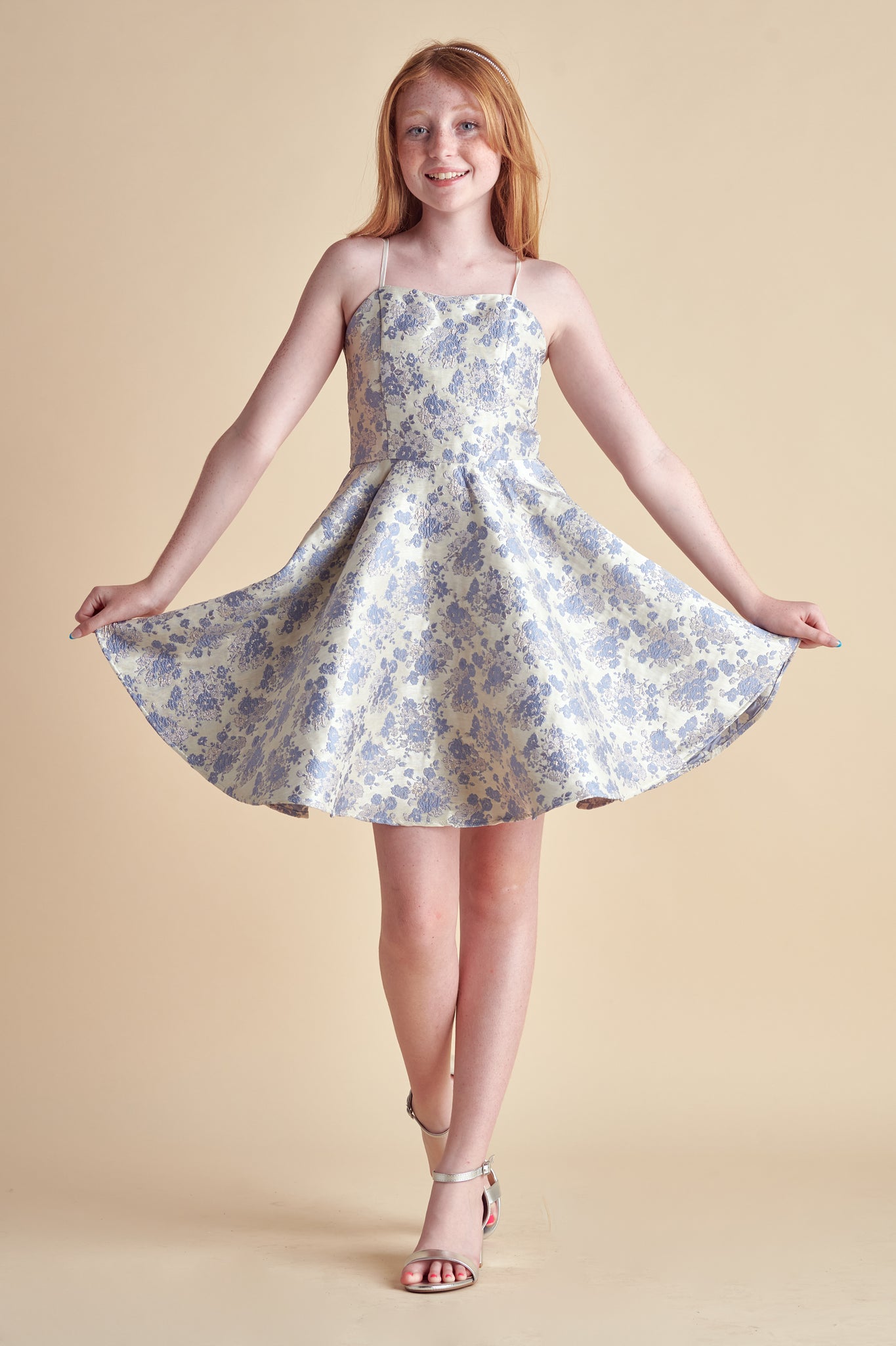 Red haired girl in a periwinkle floral fit and flare dress.