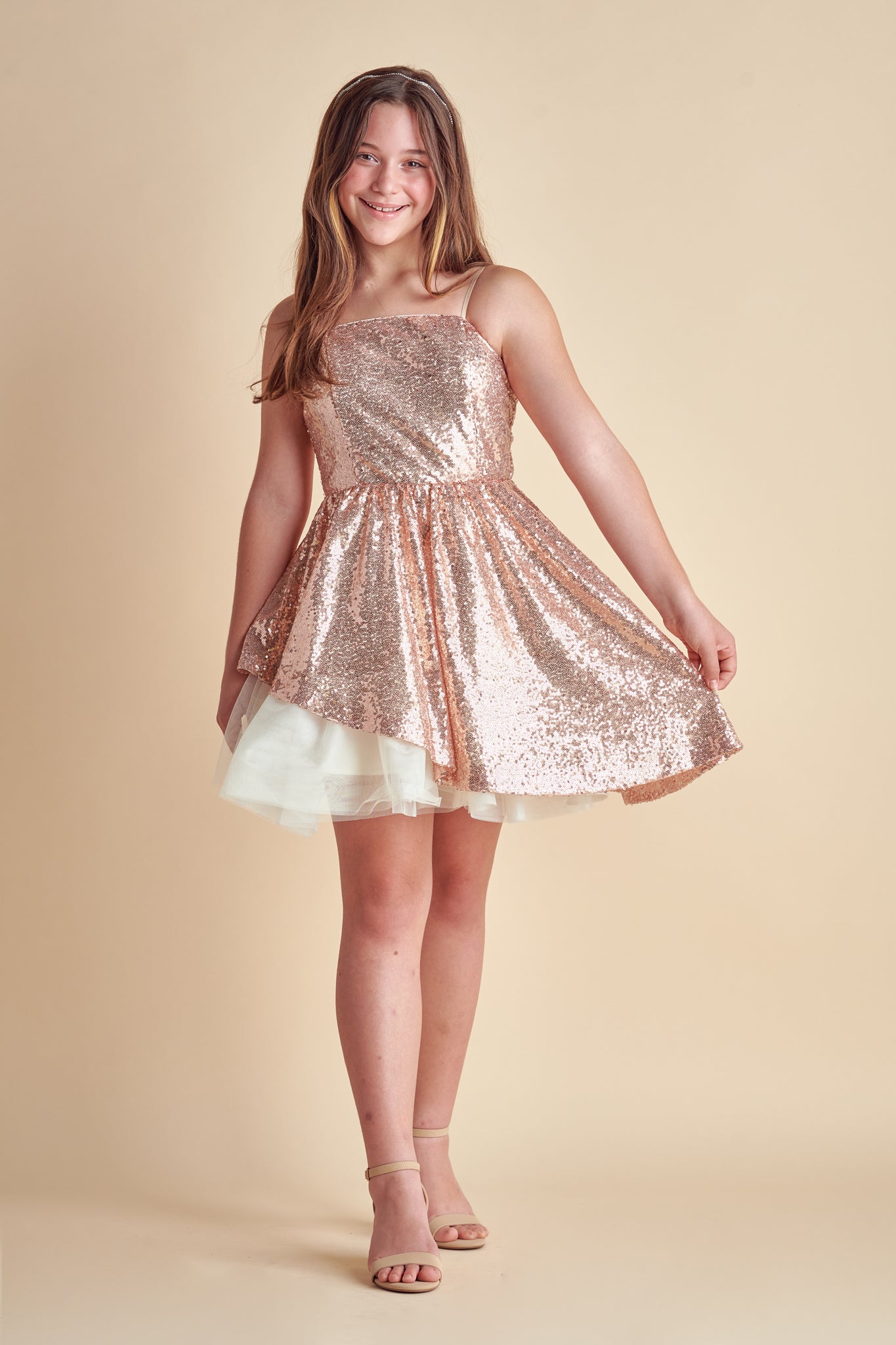 The peek-a-boo sequin dress features all over stretch sequin fabric with full circle skirt and asymmetrical skirt for a fun, twirl. Features a zipper back detailing and adjustable straps for comfort.
