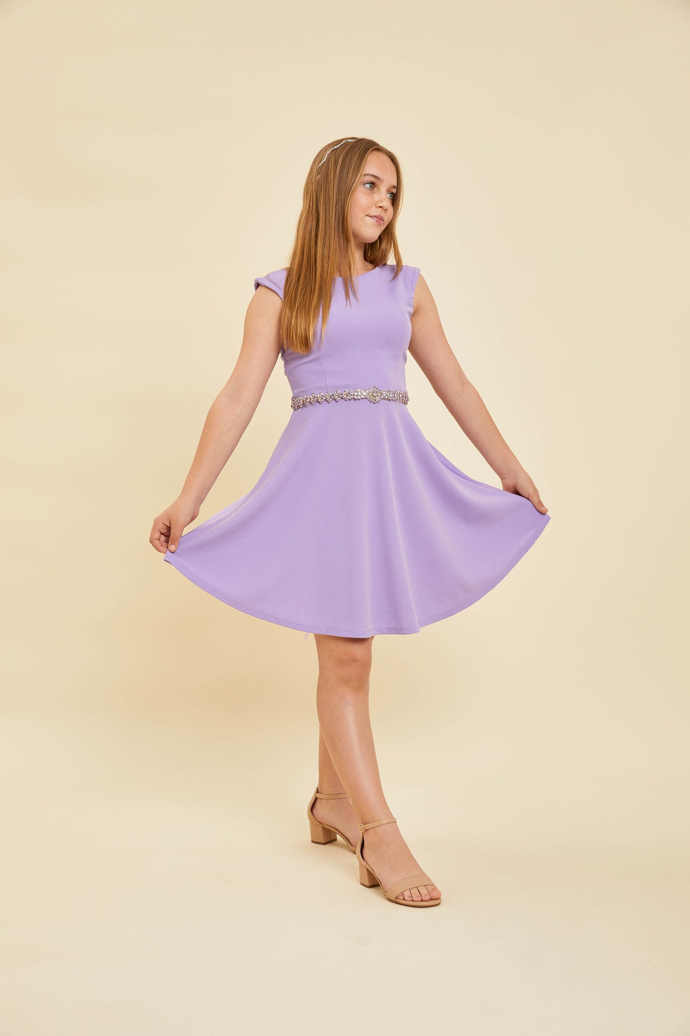 Blonde girl in a lilac cap sleeve dress.
