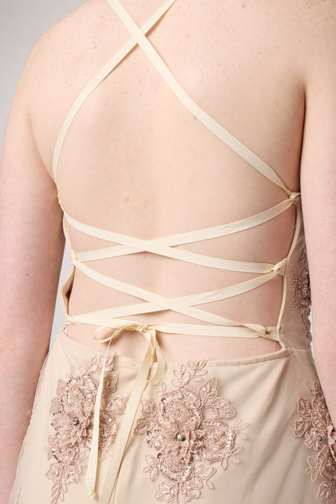 Red head in a blush pink beaded lace up back dress with nude heel.