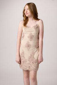 Red head in a blush pink beaded lace up back dress with nude heel.