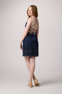 Red head in an Un Deux Trois navy beaded dress with nude heel.