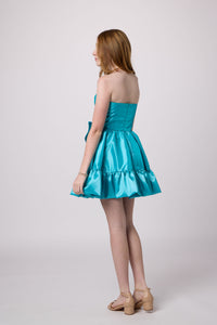 Red head in a turquoise bubble bow dress.