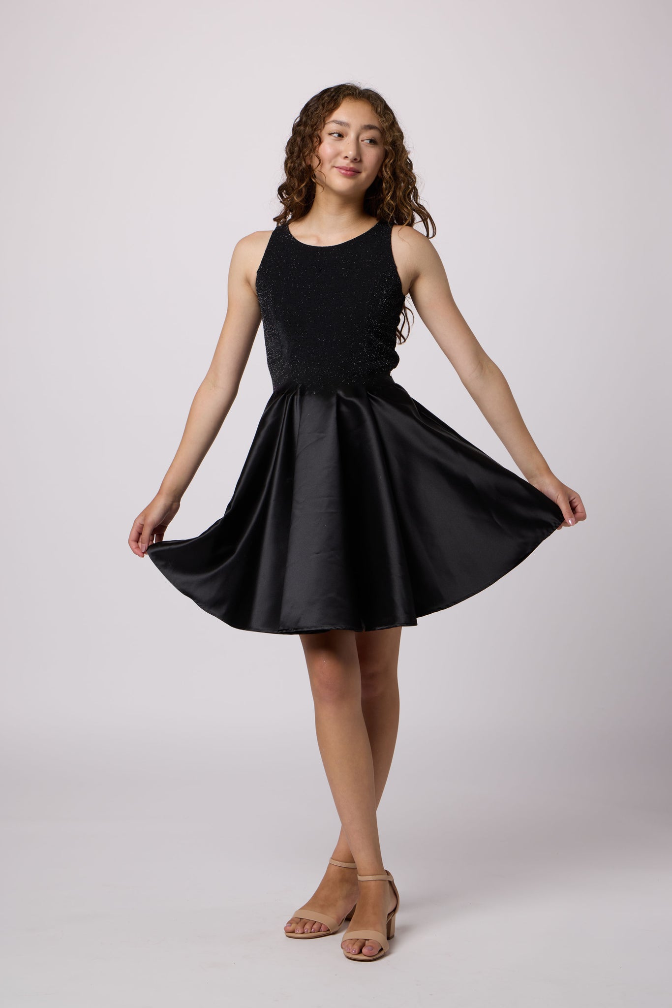 Brown haired girl in a glitter bodice dress with black circle skirt with black kitten heel.