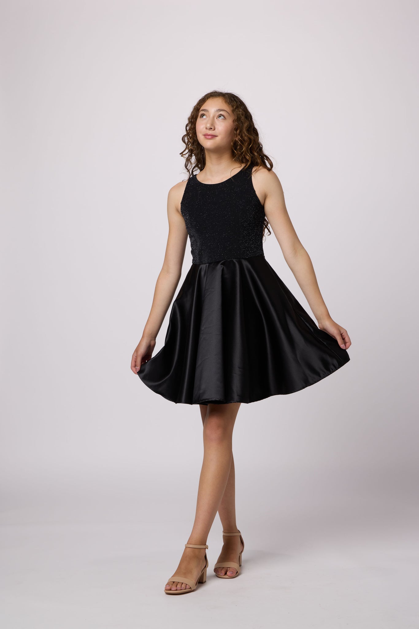 Brown haired girl in a glitter bodice dress with black circle skirt with black kitten heel.