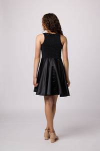 Brown haired girl in a glitter bodice dress with black circle skirt with black kitten heel.
