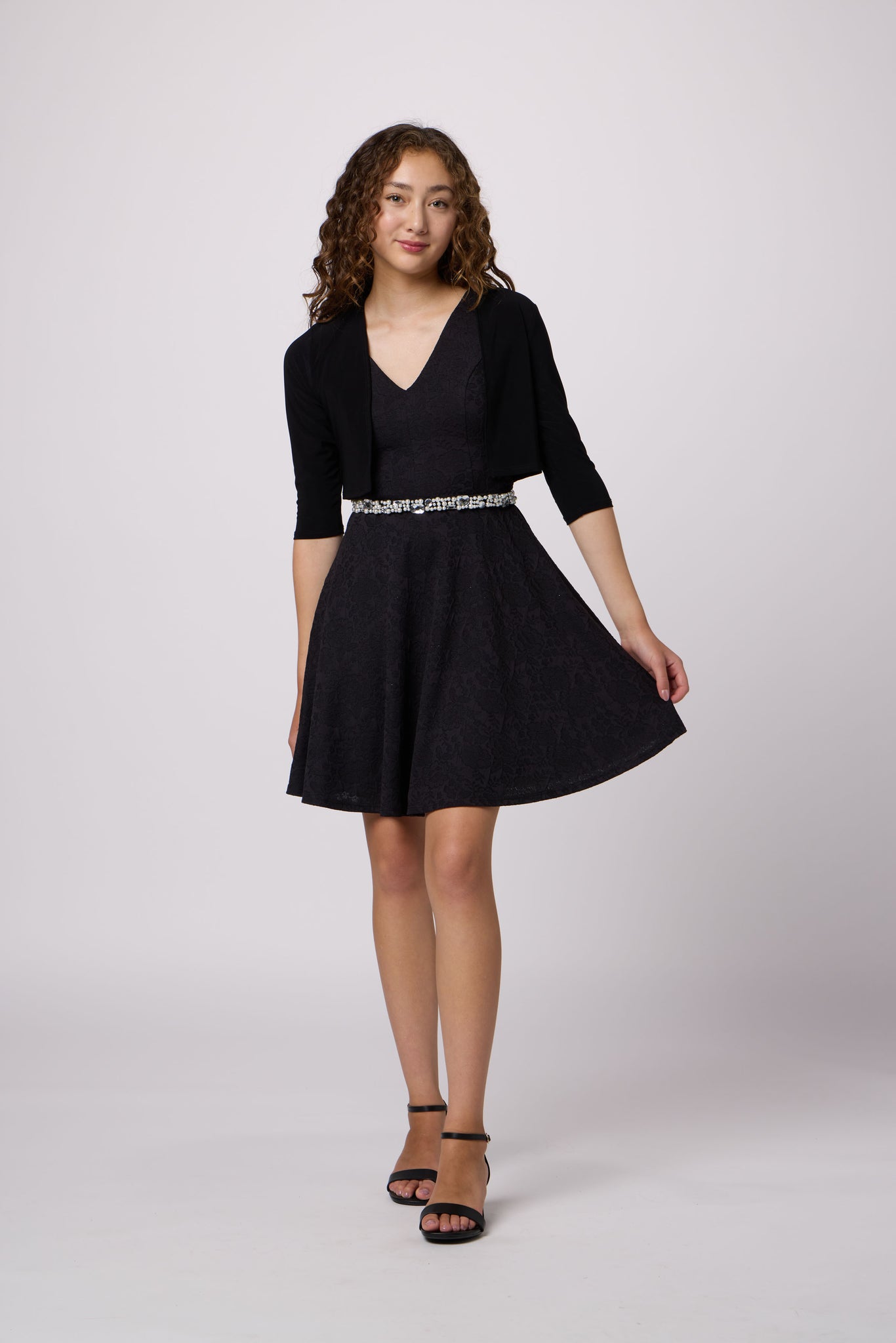 Brown haired girl in a glitter bodice dress with black circle skirt with black kitten heel.