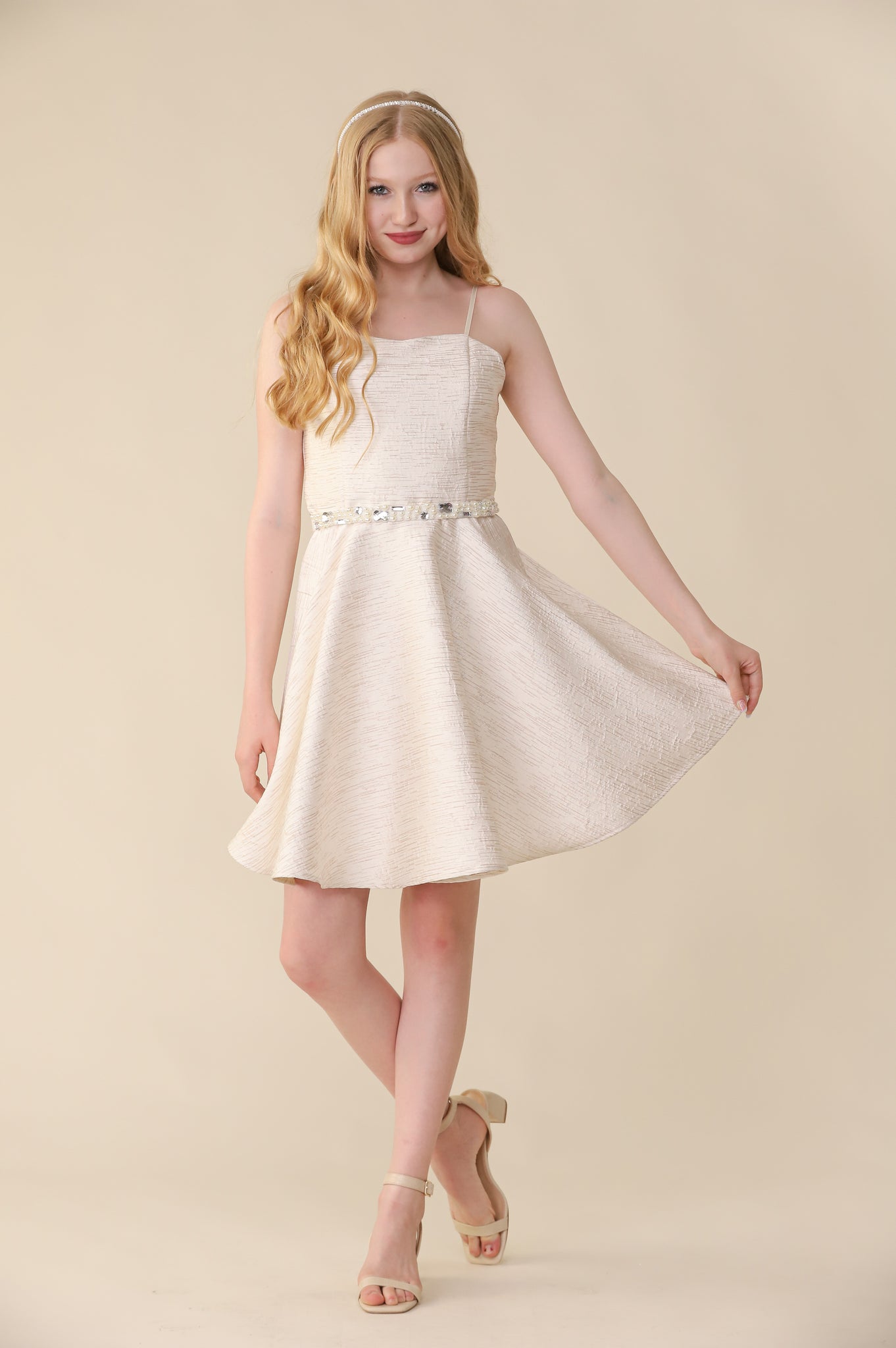 Blonde girl in ivory jacquard dress with headband.