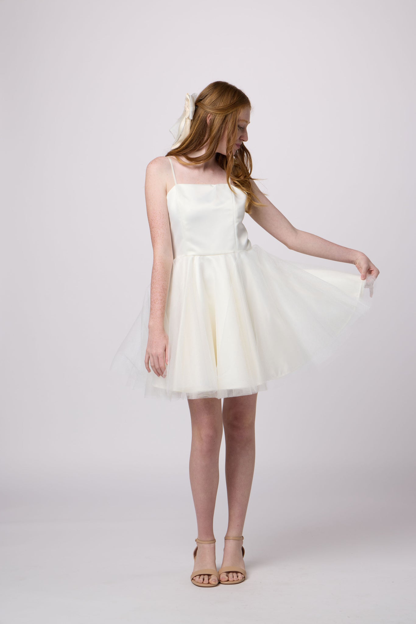 Red head girl in an Un deux Trois ivory dress.