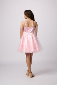 Brunette girl in an Un Deux Trois pink dress.