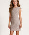 A young girl with long wavy brown hair wearing a textured burgundy and ivory sleeveless fit-and-flare dress, standing against a light gray textured studio background.