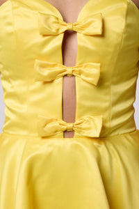 Brunette in a yellow strapless dress.