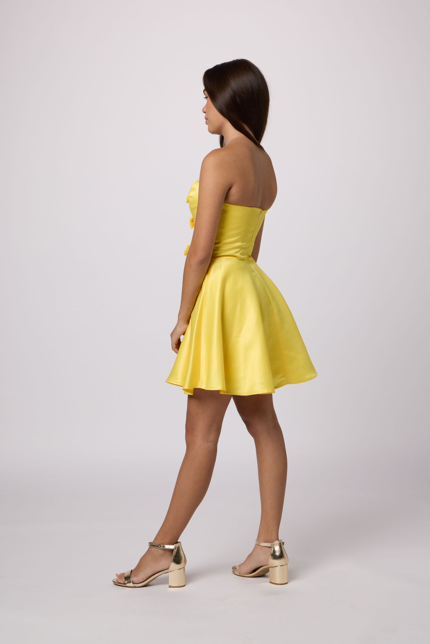 Brunette in a yellow strapless dress.