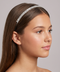 Woman wearing a sparkling headband against a neutral background