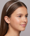 Young girl wearing a decorative headband against a neutral background