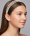 Woman wearing a pearl headband against a gray background