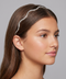 Woman wearing a decorative headband against a gray background