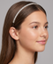 Woman wearing a decorative headband against a neutral background