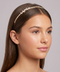 Woman wearing a decorative headband against a neutral background