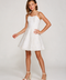 A young girl modeling a white spaghetti-strap mini dress with a flared skirt, paired with beige block-heel sandals, against a light gray studio background.