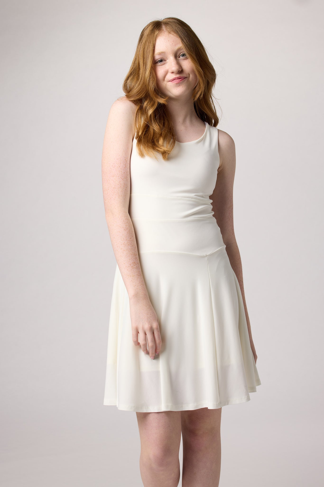 Red head girl in an Un Deux Trois skater dress in ivory with nude heel.