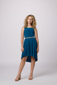 Blonde girl in a teel Un Deux Trois pleated high low dress with belt.