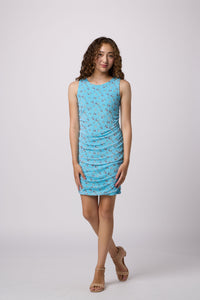 Brunette girl in an Un Deux Trois aqua floral fitted ruched dress.