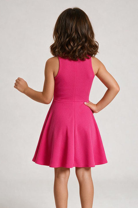 A young girl with brown hair is shown from behind wearing a sleeveless hot pink skater dress against a light gray studio background.