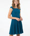 Young girl wearing a teal dress on a white background