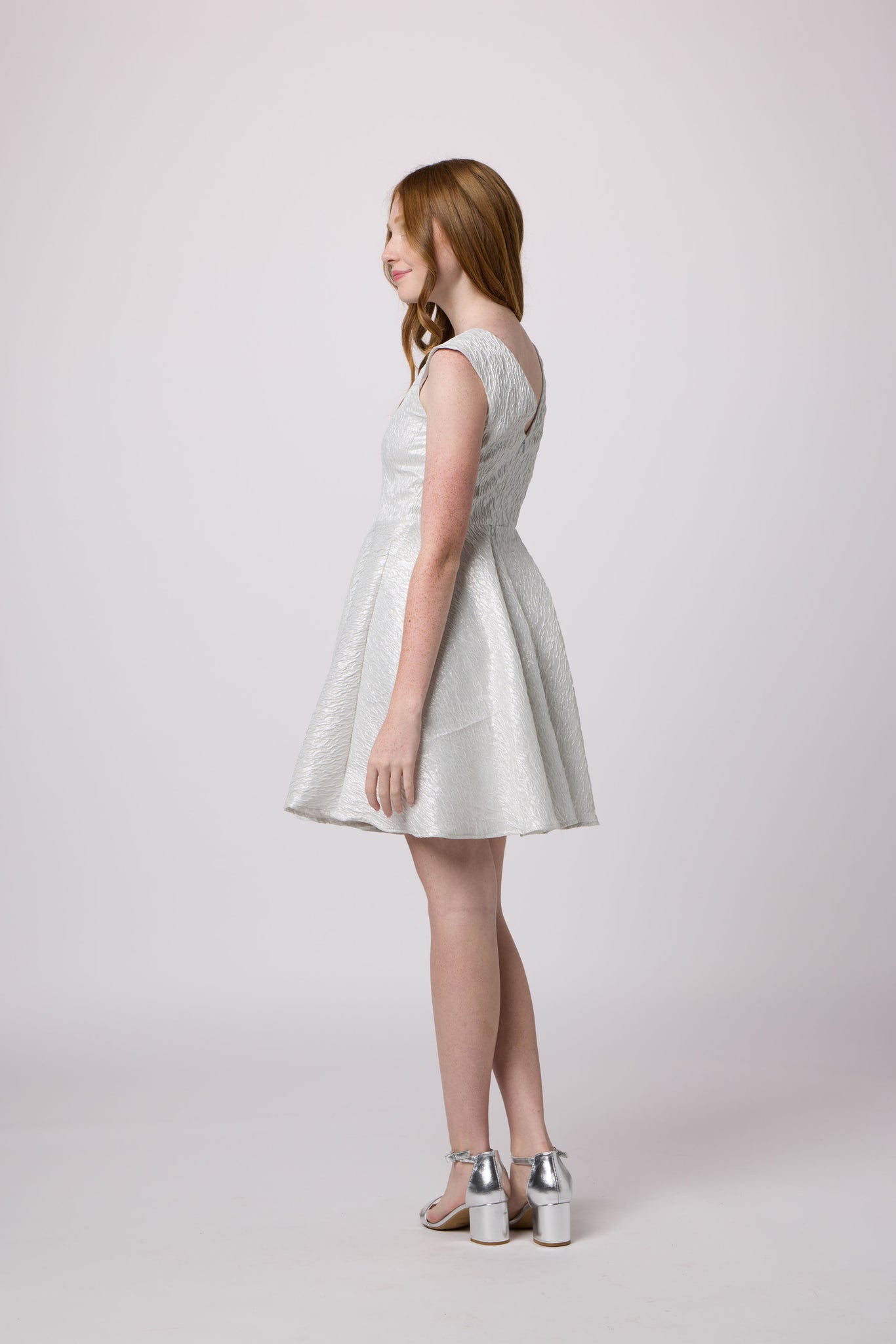 Red head in a cap sleeve silver dress.