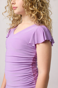 Blonde girl in an Un Deux Trois lavender flutter sleeve dress.