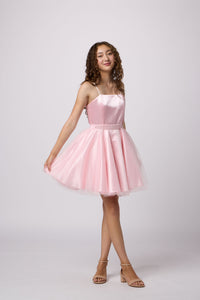 Brunette girl in an Un Deux Trois pink dress.