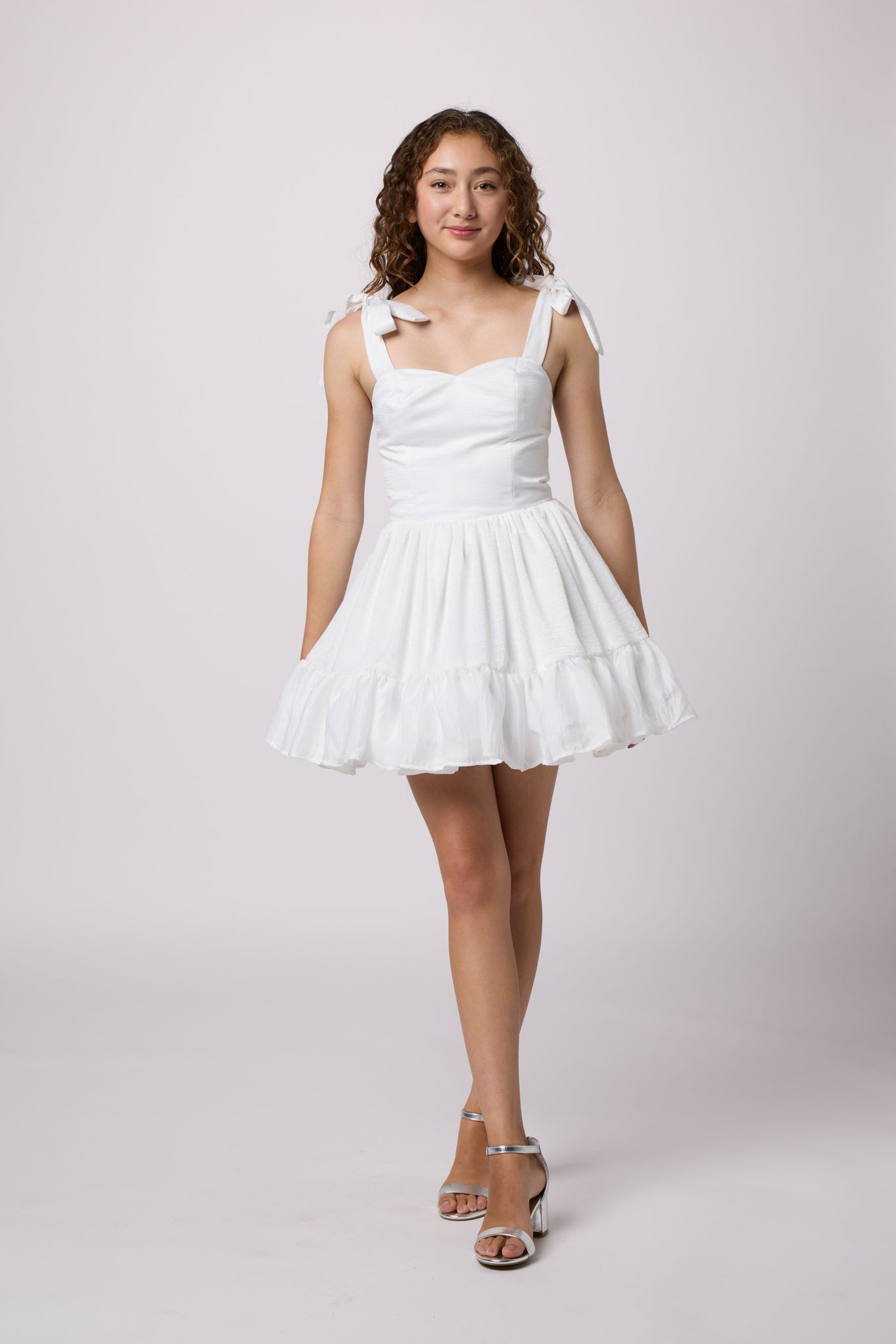 Brunette girl in a white Un Deux Trois Petite Junior dress.