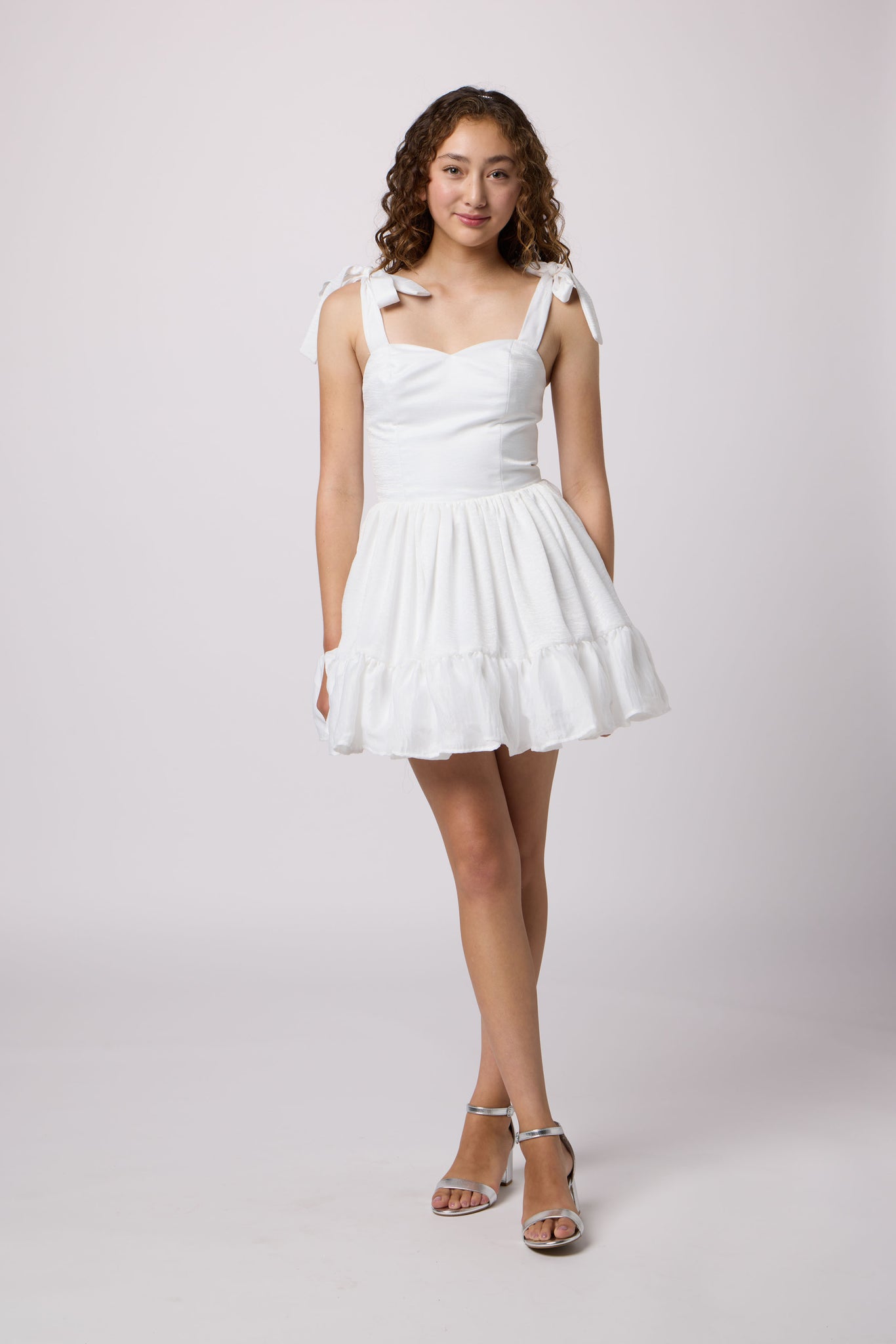 Brunette girl in a white Un Deux Trois Petite Junior dress.