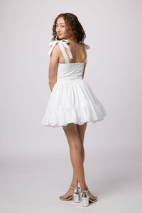 Brunette girl in a white Un Deux Trois Petite Junior dress.