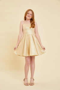 Red head in a gold glitter fit and flare dress and nude shoe.