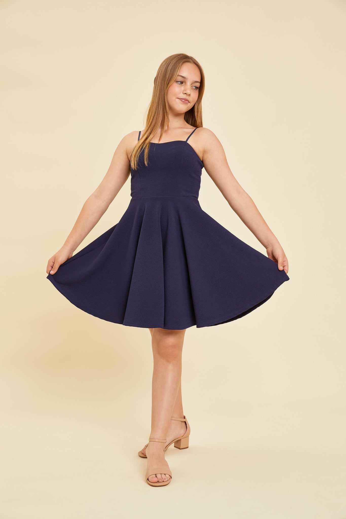 Blonde girl in a navy textured fit and flare dress.Blonde girl in a navy textured fit and flare dress back.