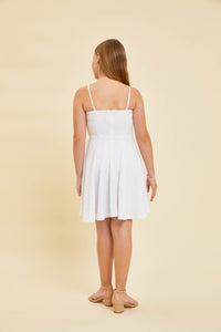 Girl in a white fit and flare dress with nude heel.