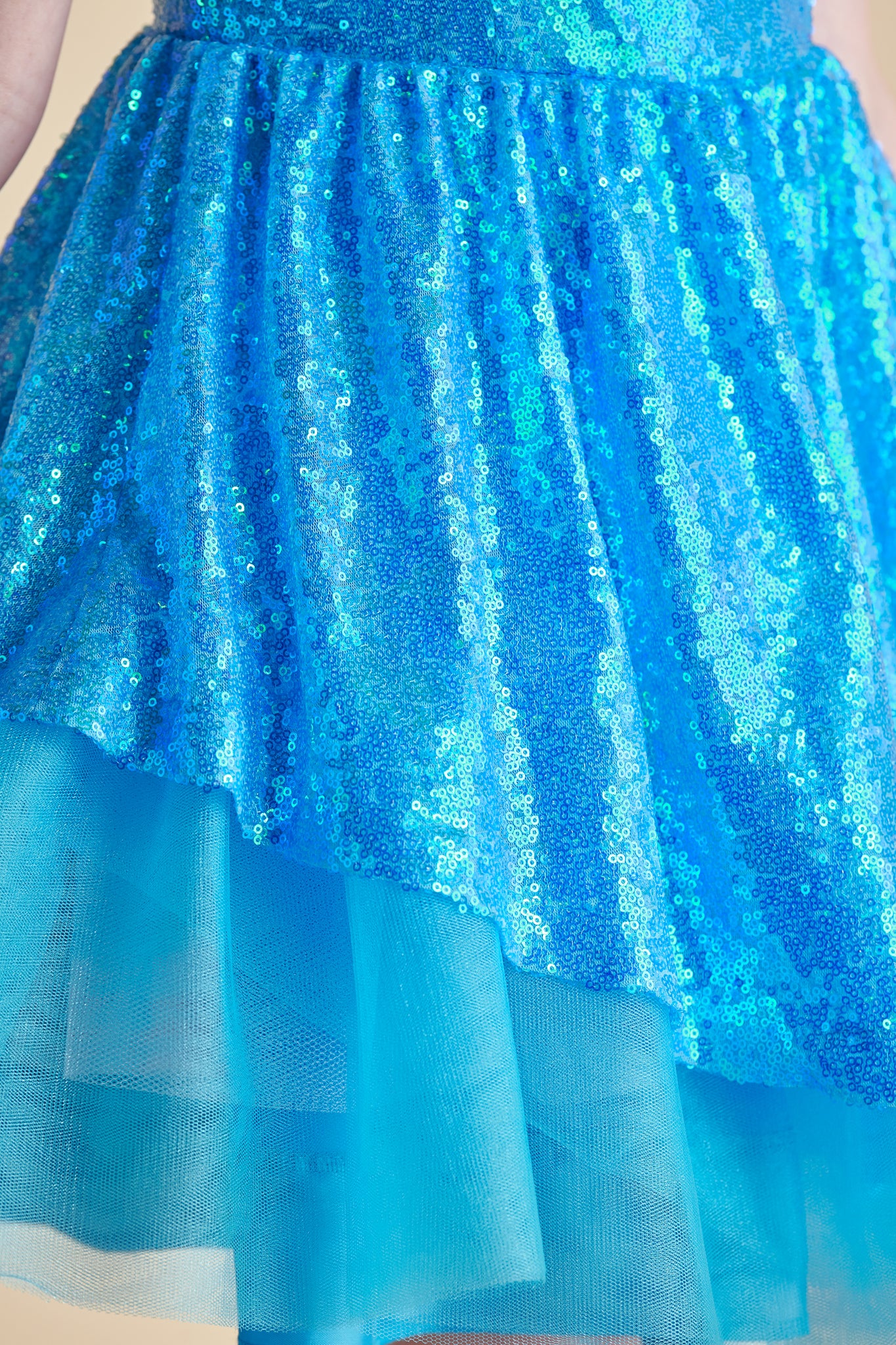 Red head in a turquoise all over sequin dress with full circle skirt.