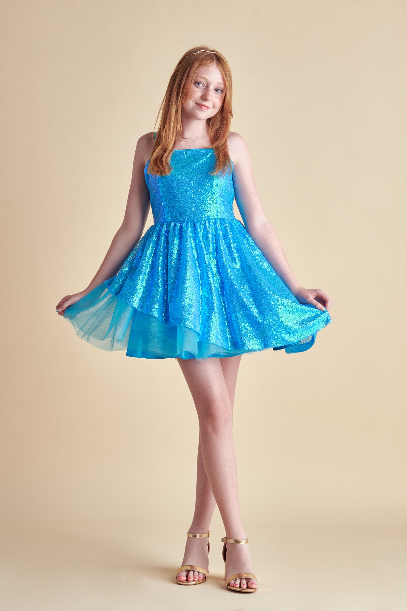Red head in a turquoise all over sequin dress with full circle skirt.