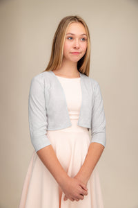 Girl wearing a silver bolero jacket. 