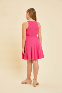 Blonde girl in a hot pink fuchsia textured racerback dress with nude heels.