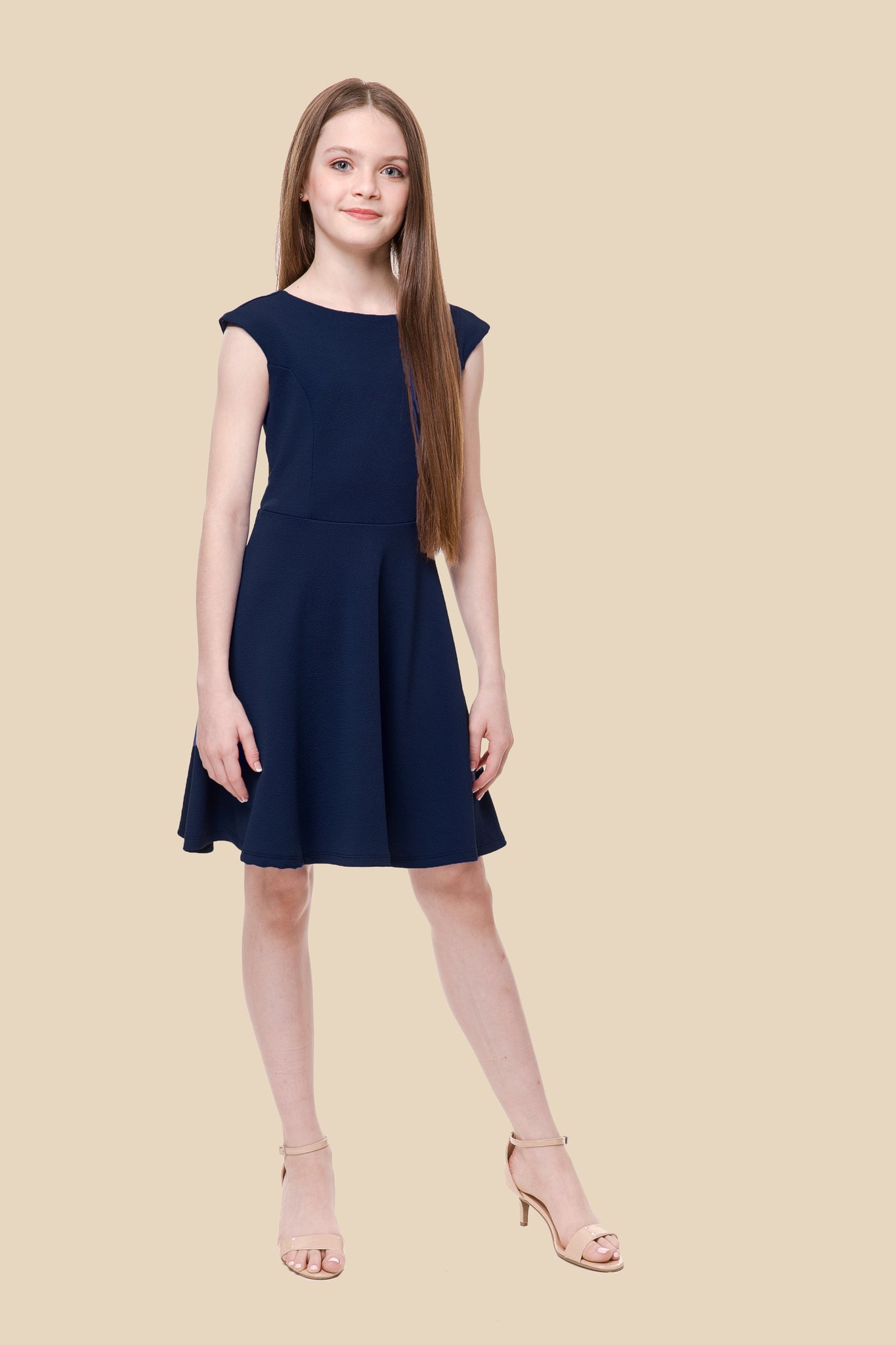 The cap sleeve textured fit and flare dress is shown in nabvy blue with high neck line, shoulder coverage and lower v-back detailing for a chic and sophisticated look. This dress can be worn to a more coservative special occasion event like cotillion, graduation, or religious service like a bat mitzvah service or church ceremony.