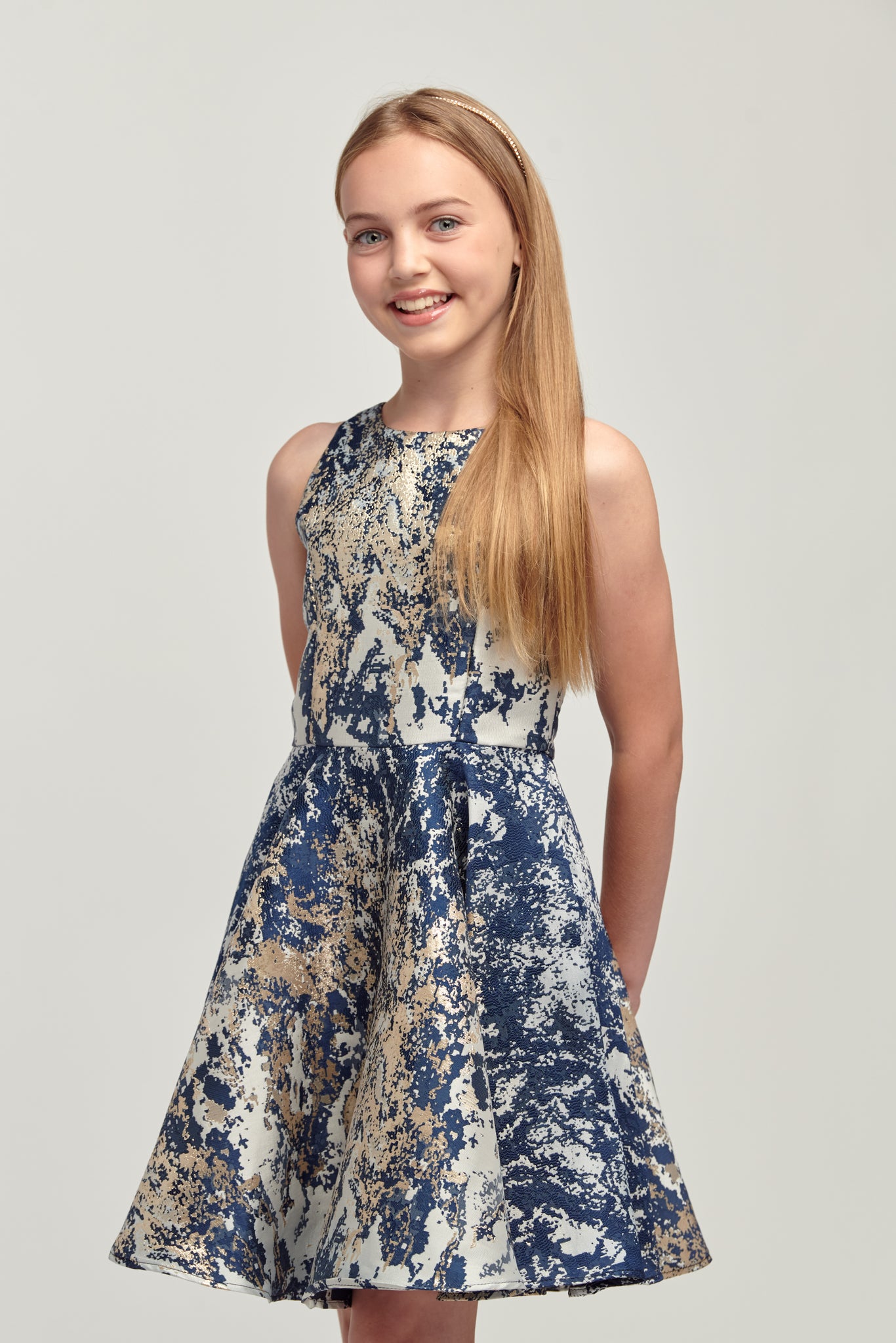 Young girl in navy and gold floral racerback style dress.