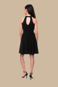Halter dress in black features a full circle twirl skirt, open hole detailing in back and high waist line for a chic silhouette.