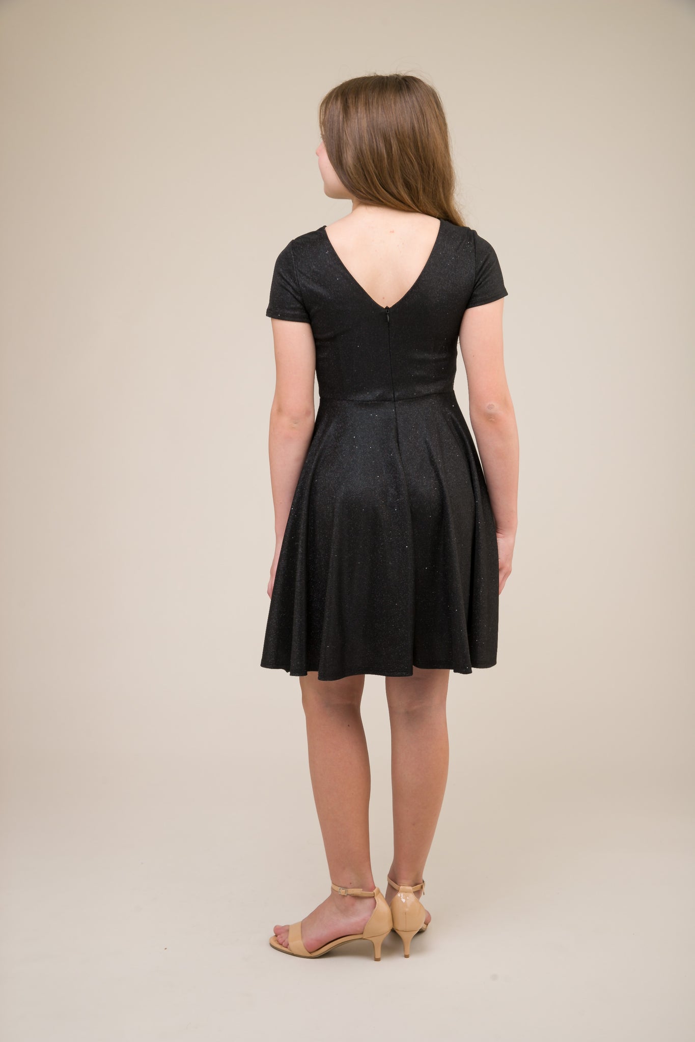 This is an all over black stretch glitter dress made with soft lining. It's non-scratch fabric is a perfect dress that hits right above the knee and has a lower v-back detailing.