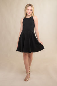 The tank style sleeve textured fit and flare dress is shown in black with high neck line, racerback detailing and dart bodice for a chic and sophisticated look. This dress can be worn to a more conservative special occasion event like cotillion, graduation, or religious service like a bat mitzvah service or church ceremony.